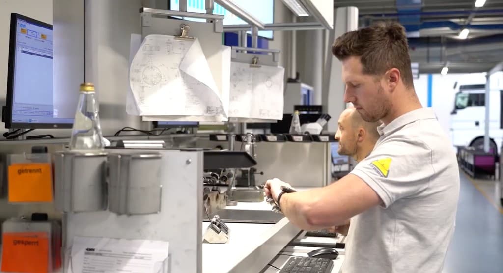 Assembly operator reviewing an engineering drawing on a smartwatch at the workstation