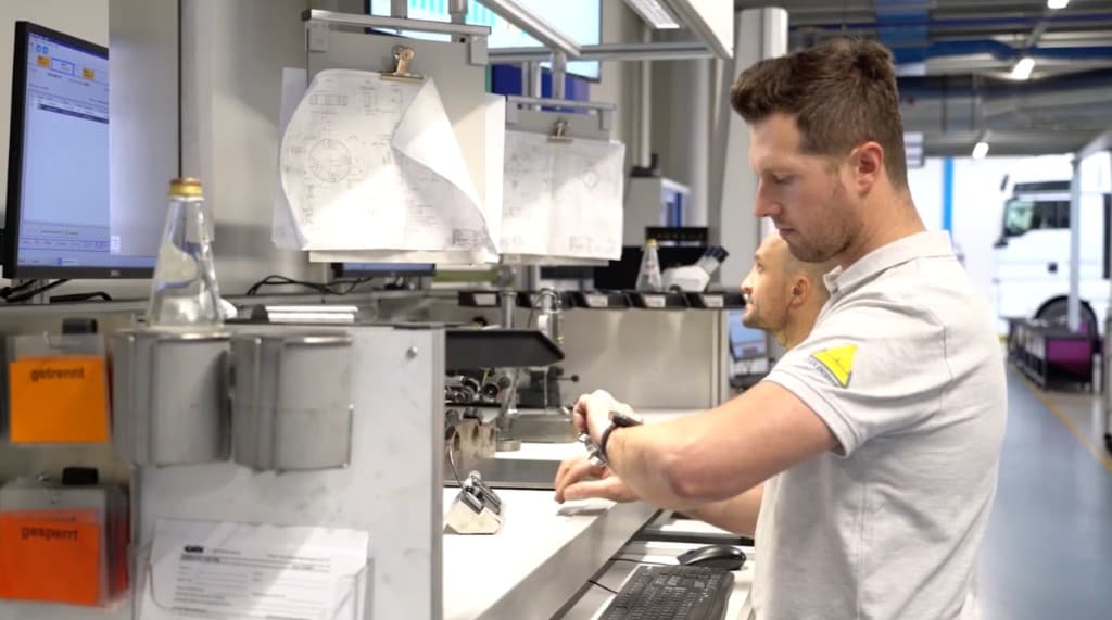 Operator reviewing work instructions on a smartwatch at a machine operations workstation